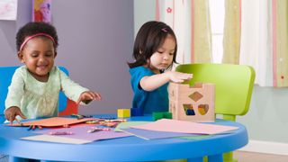 Toddlers coloring and playing with blocks at daycare -