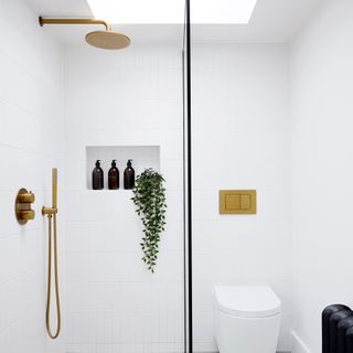 White shower room with skylight and brass fittings