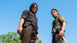 En bild på Daryl och Rick i HBO Max-serien The Walking Dead som står bredvid varandra och kollar ned på något.