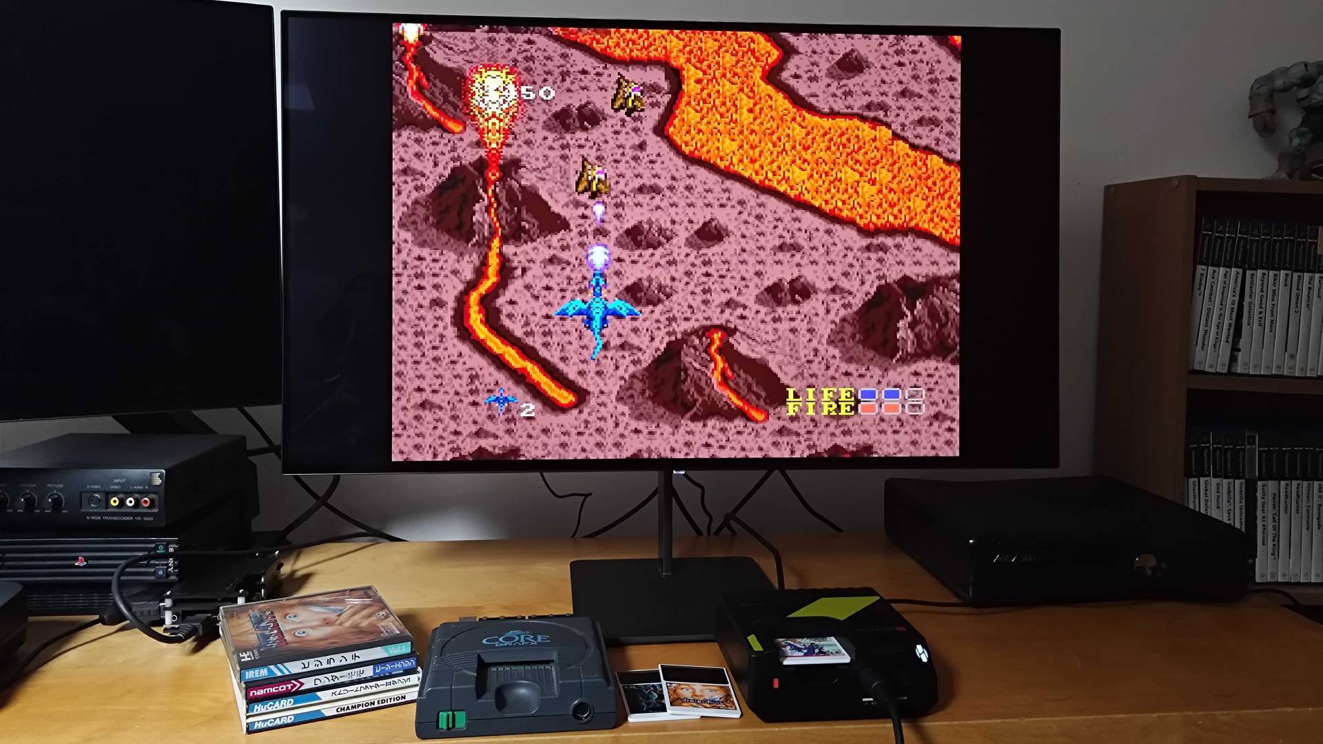 Hyperkin Retron GX running Dragon Spirit next to PC Engine beneath monitor.