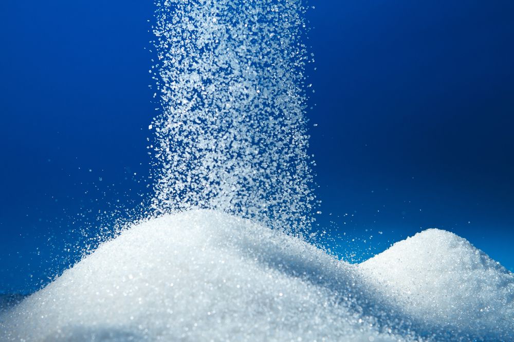 Sugar is piled up into dunes, with more sugar raining down on top.