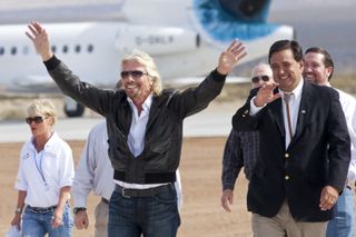 Richard Branson, center, arrives with New Mexico Governor Bill Richardson, right, at an event commemorating the completion of the Virgin Galactic Spaceport America runway in Upham, New Mexico, U.S., on Friday, Oct. 22, 2010.