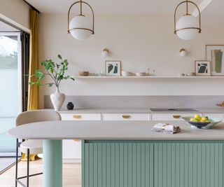 white kitchen worktop on mint green kitchen island with white bar stools