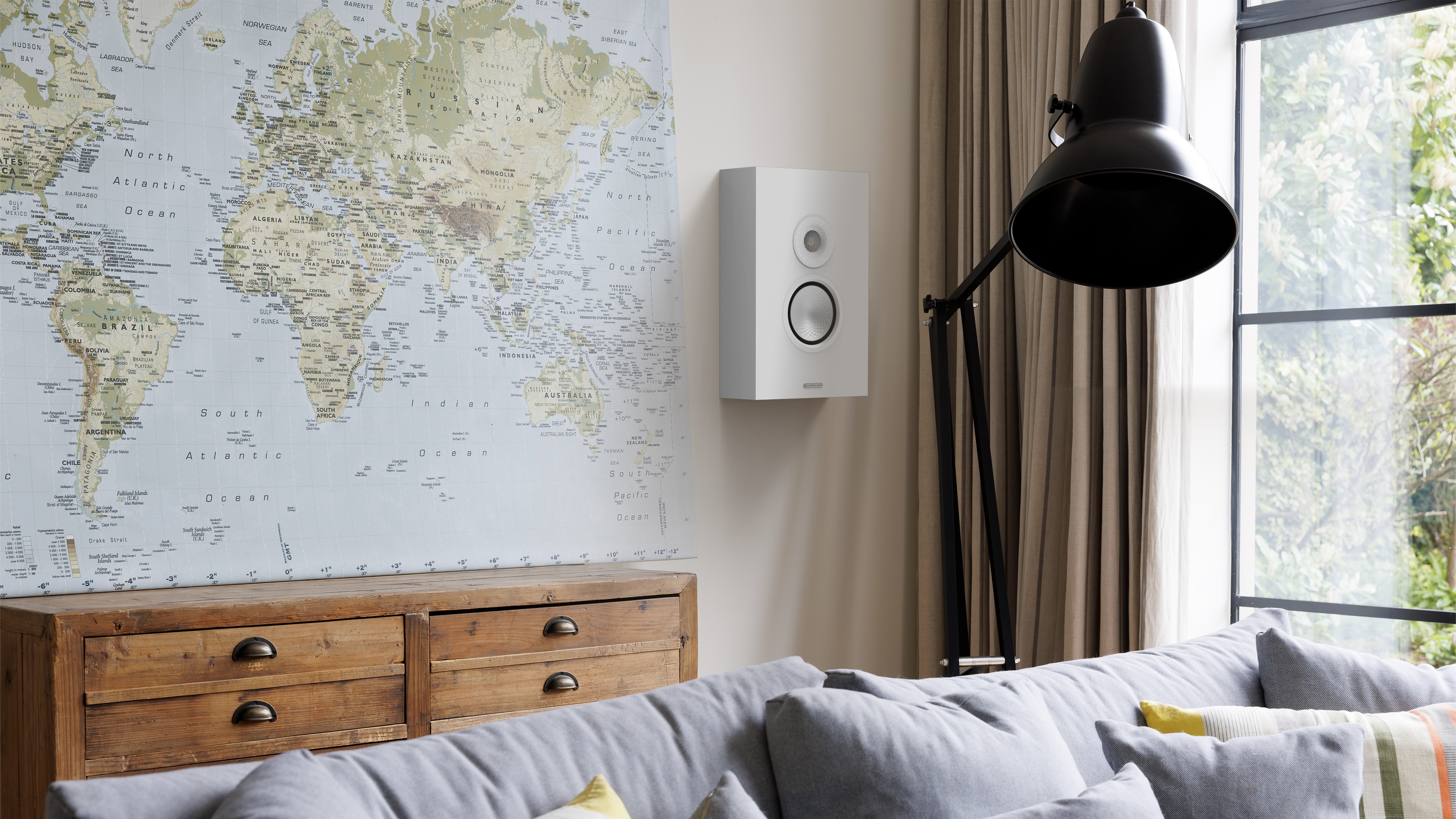 Monitor Audio Silver On-Wall 8G mounted on wall in living room next to map and window