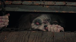 A zombie peeks out from under a floorboard in 'The Evil Dead'