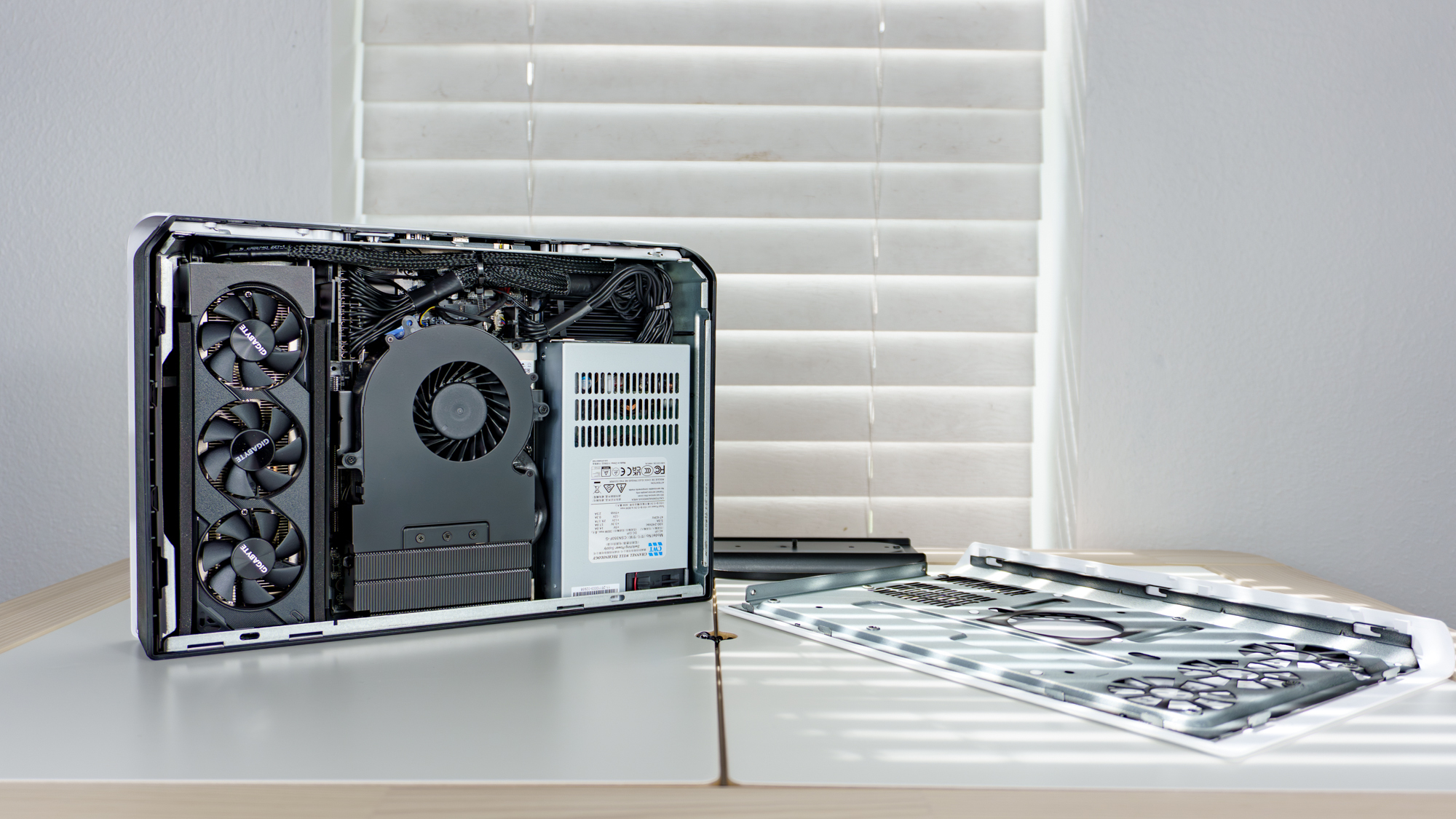 The Minisforum G1 Pro open on a table with its lid visible