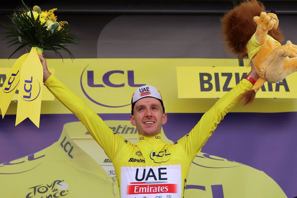 UAE Team Emirates British rider Adam Yates celebrates on the podium with the overall leaders yellow jersey after the 1st stage of the 110th edition of the Tour de France cycling race 182 km departing and finishing in Bilbao in northern Spain on July 1 2023 Photo by Thomas SAMSON AFP Photo by THOMAS SAMSONAFP via Getty Images