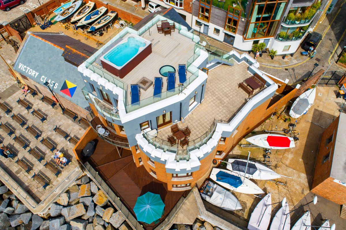 A brick house with a hot tub on the roof and balcony area