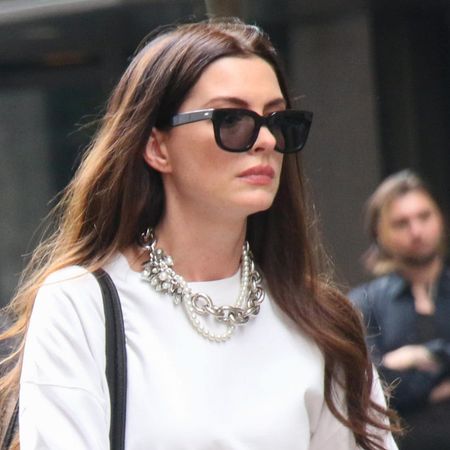 Anne Hathaway films The Devil Wears Prada 2 wearing white pants and a white top and carrying a vintage Coach briefcase