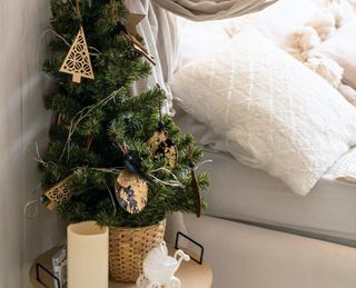 a small christmas tree on a nightstand in a bedroom