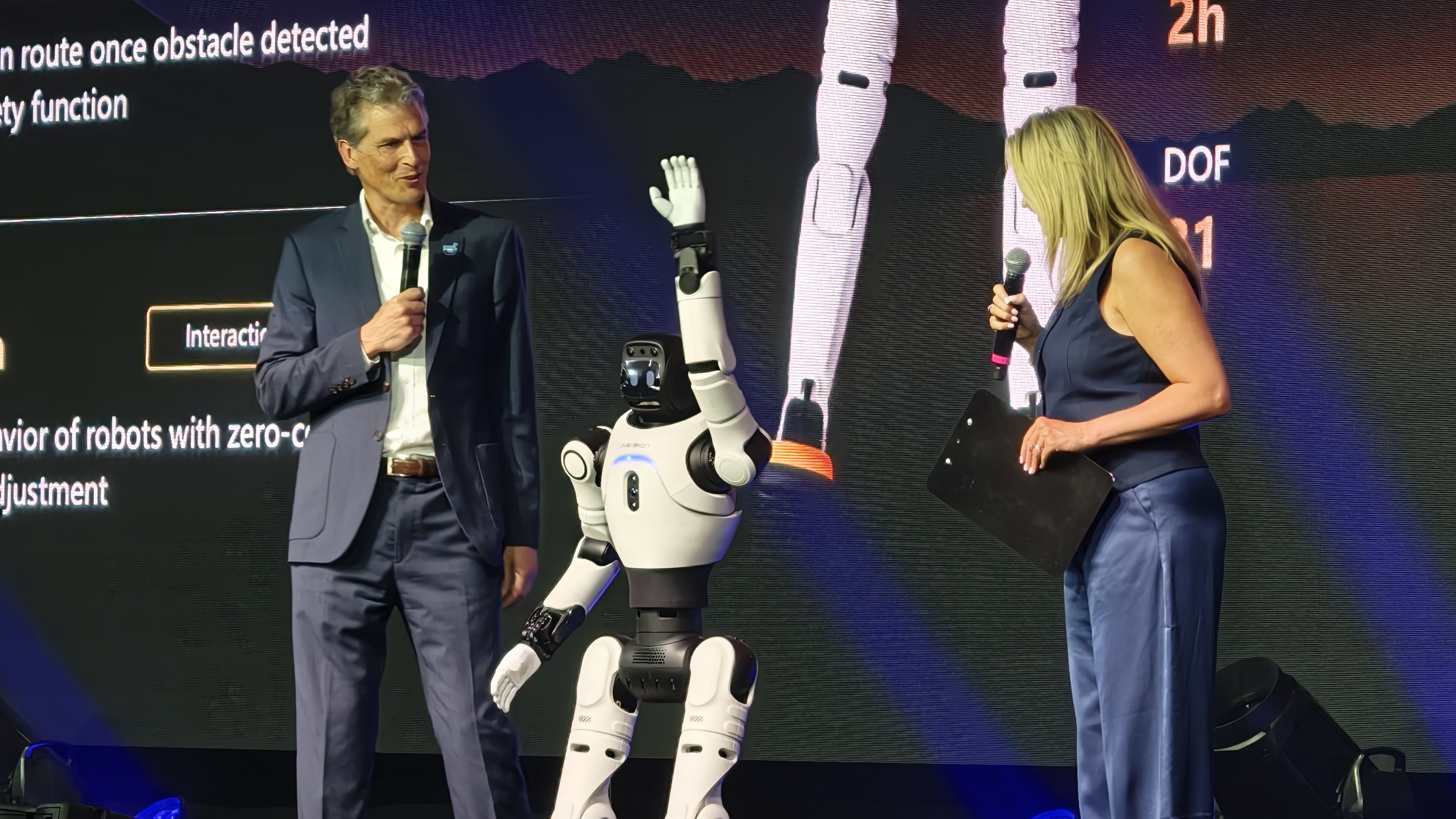 An AGIBOT X2 robot waves to the crowd on stage