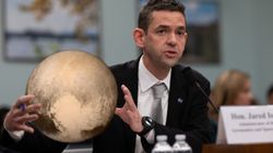 a man in a suit speaks into a microphone