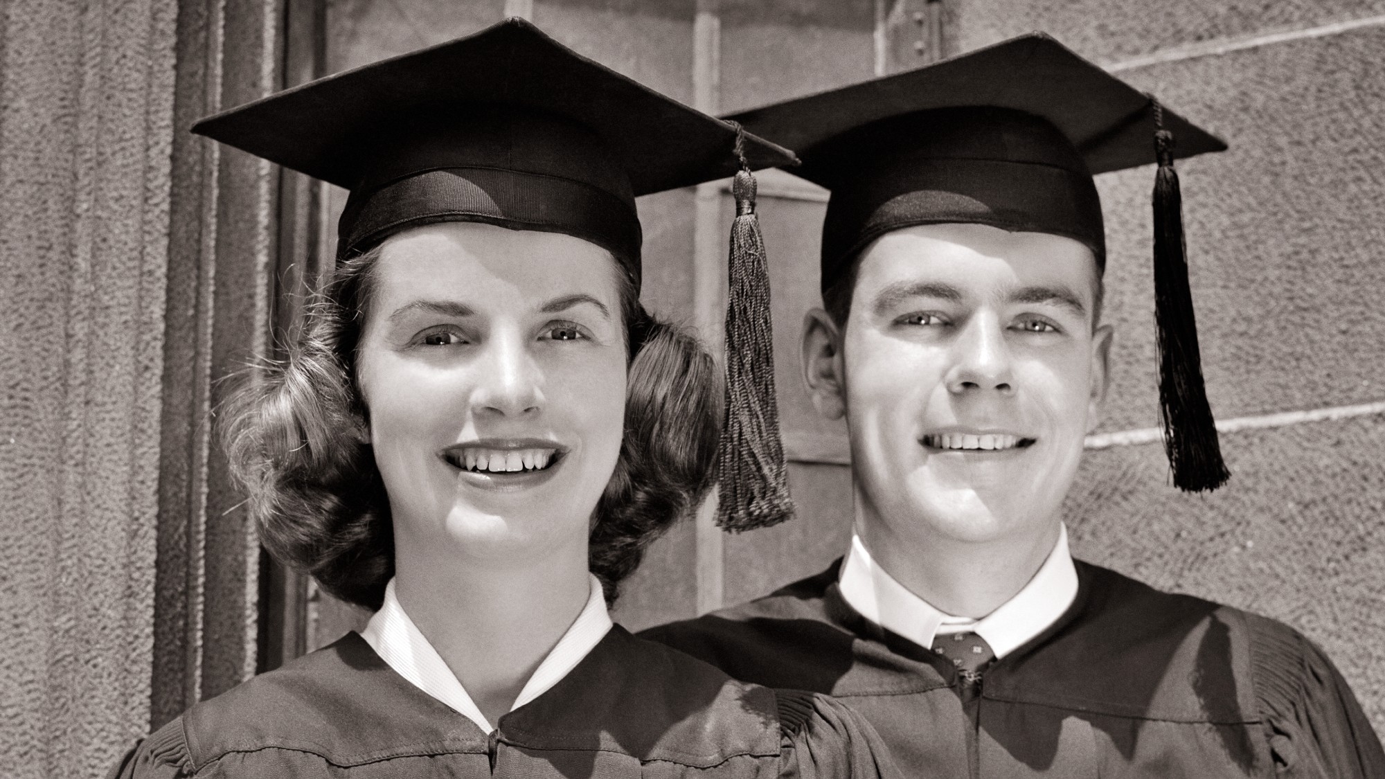 1950s man and woman in college graduation caps and gowns