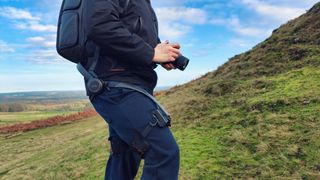 Person using a Hypershell X Ultra exoskeleton on a grassy hill