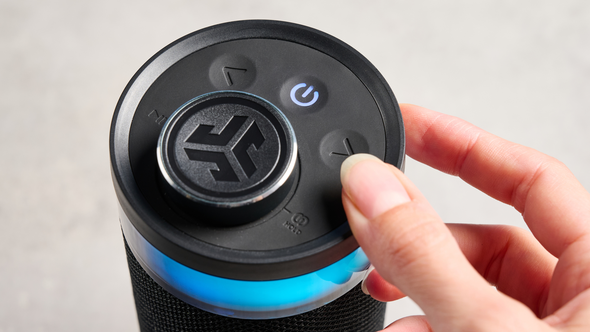 the jlab go party speaker in black with an LED RGB panel and jlab logo photographed in front of a blue background