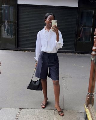 Sylvie in navy shorts and a white blouse