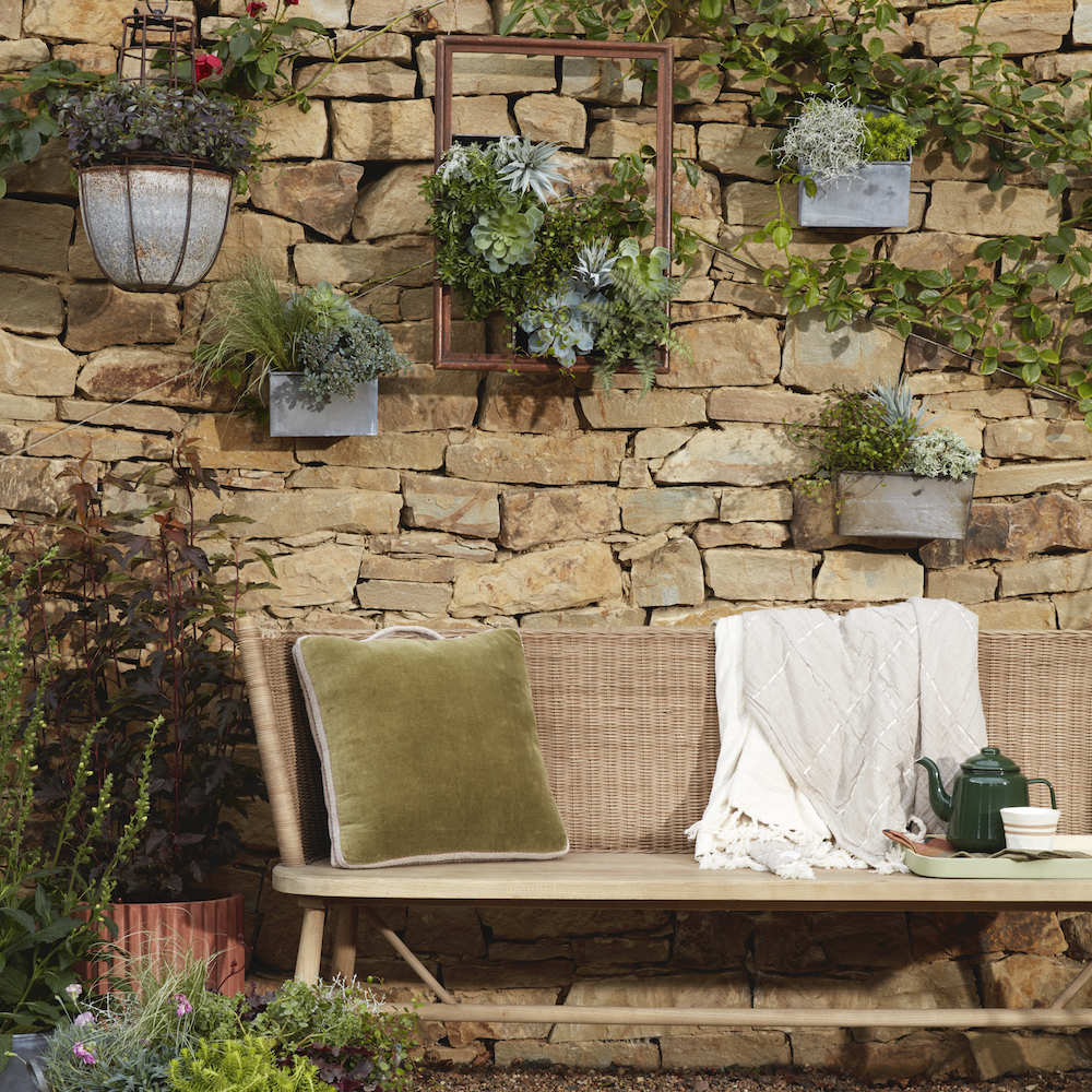 metal plant pots attached with stone garden wall