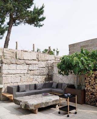 Courtyard with grey sofa and stone walls