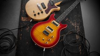 Two guitars lying on the floor with guitar cables