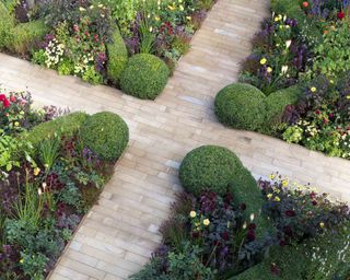 parterre garden planted with herbaceous flowers and paved pathways in a design by Matt Keightley Rosebank Landscaping