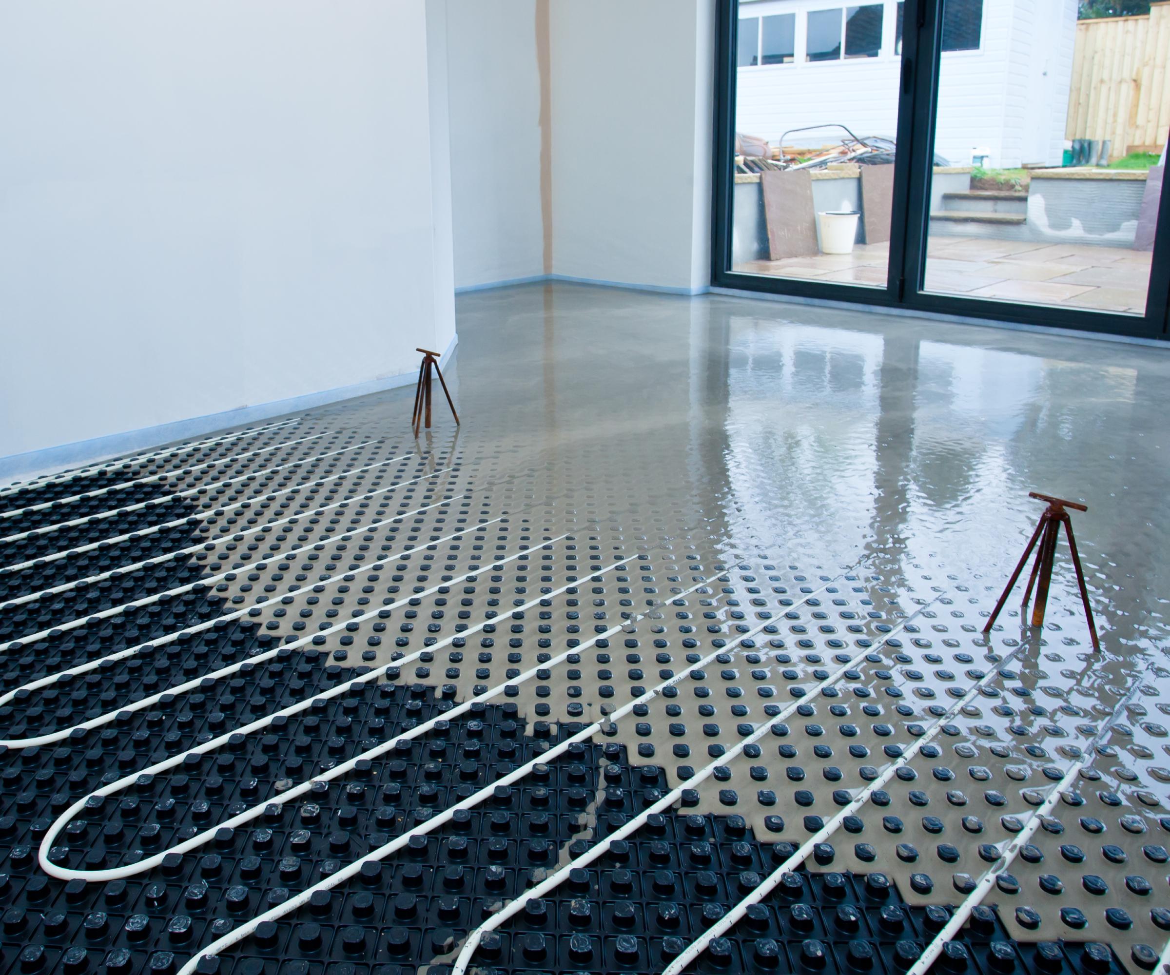 screed being poured over underfloor heating pipes