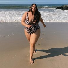 Model running on beach wearing plus size bikini