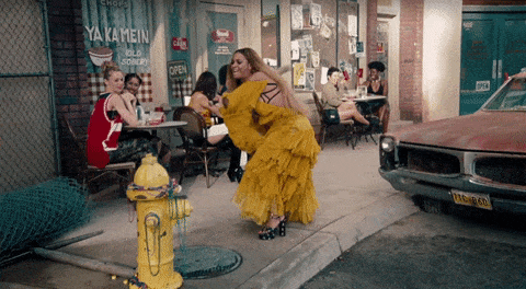 Beyonce hitting a fire hydrant with a baseball bat