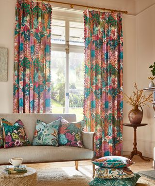 Colorful destination inspired floor length curtains with coordinating scatter pillows on sofa.