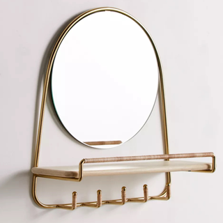A circular mirror with shelf and hooks