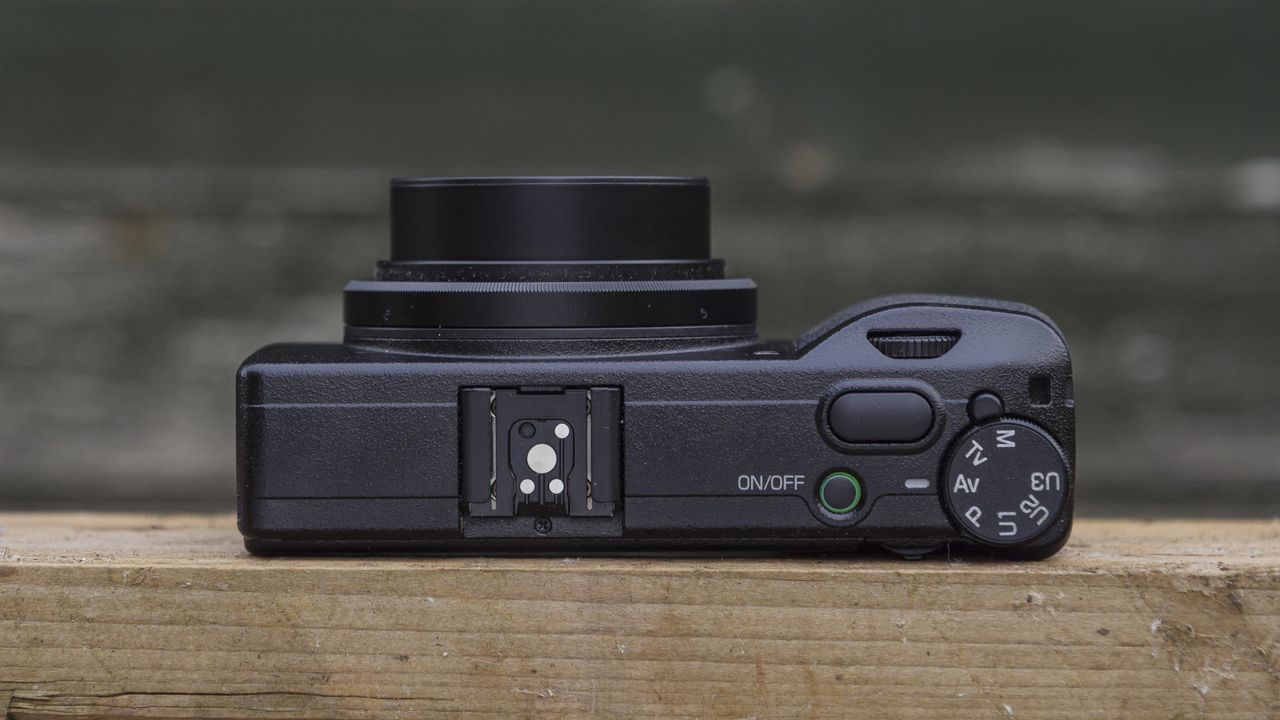 The Ricoh GR IIIx camera on a wooden table