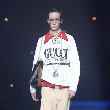 A model walks the runway in Gucci clothing.