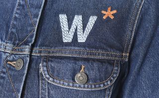 A denim shirt with a button on the pocket and a "W*" above it.