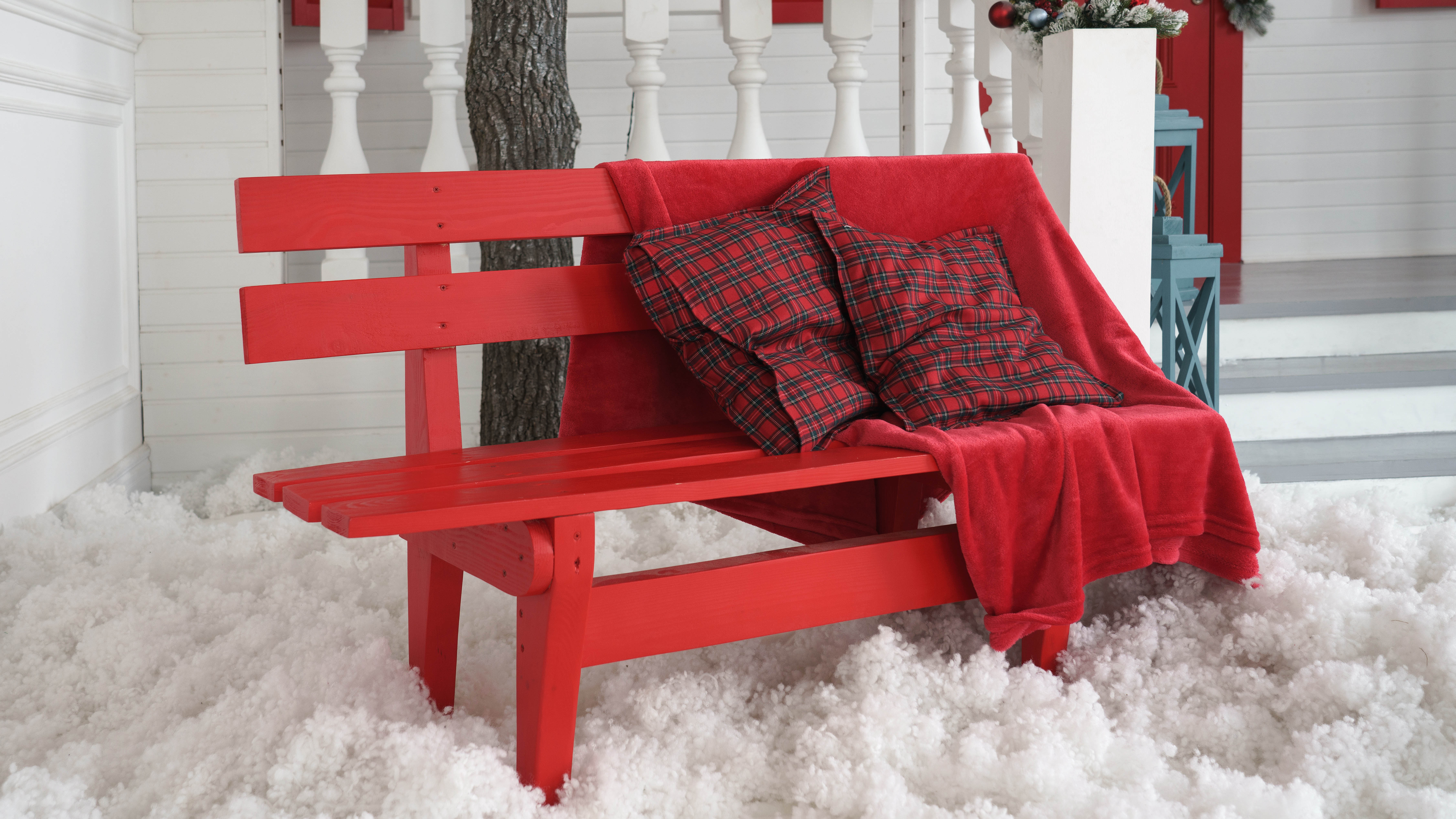 Две подушки и одеяло на красной скамейке