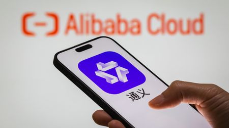 A smartphone displays Alibaba's AI-powered assistant Tongyi. 