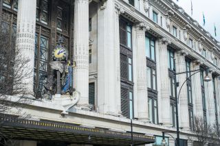 Facade of the Selfridges department store , with the statue of an angel holding a clock