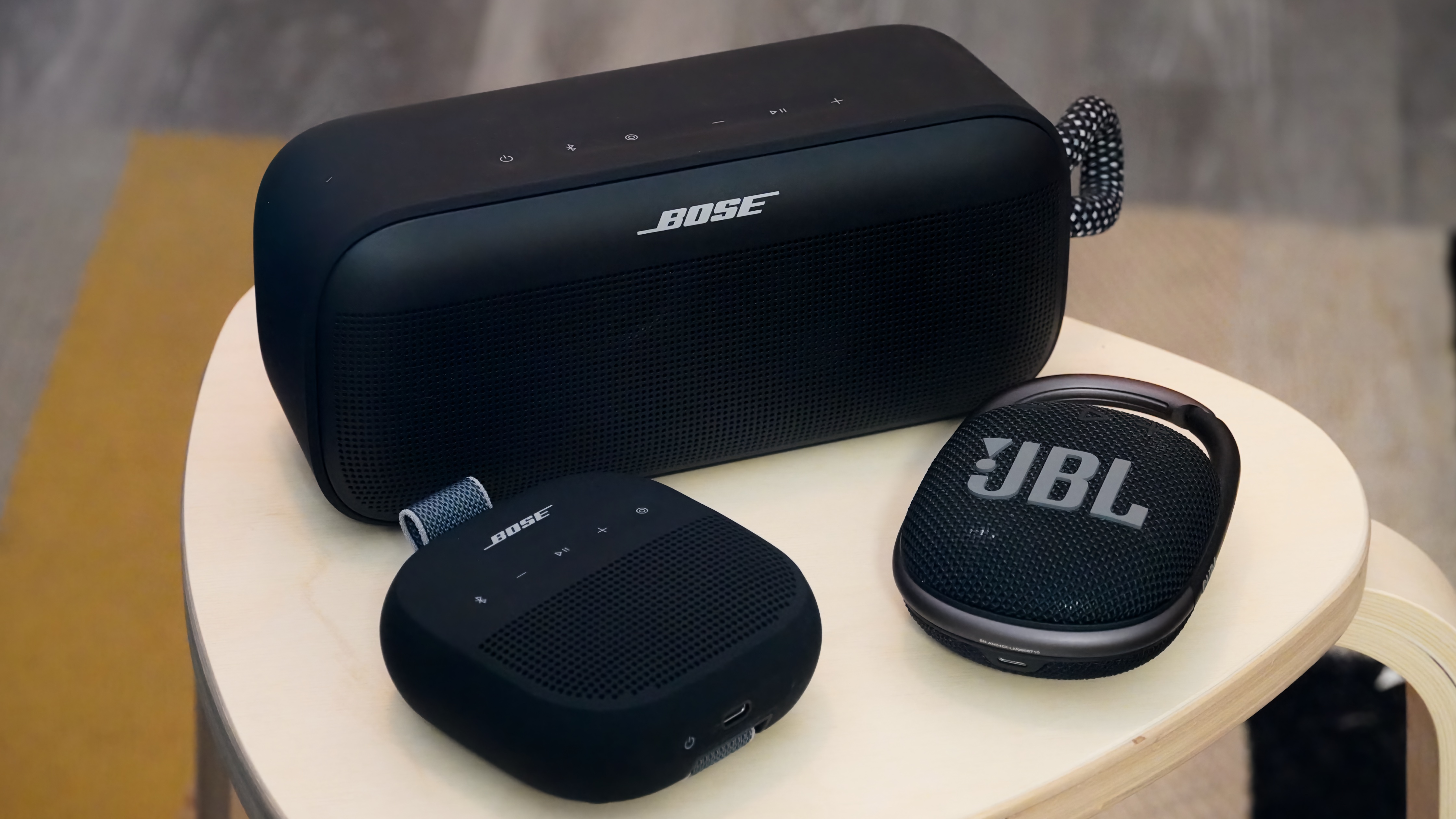 The Bose SoundLink Micro 2 in black next to a JBL Clip and a Bose SoundLink Plus.