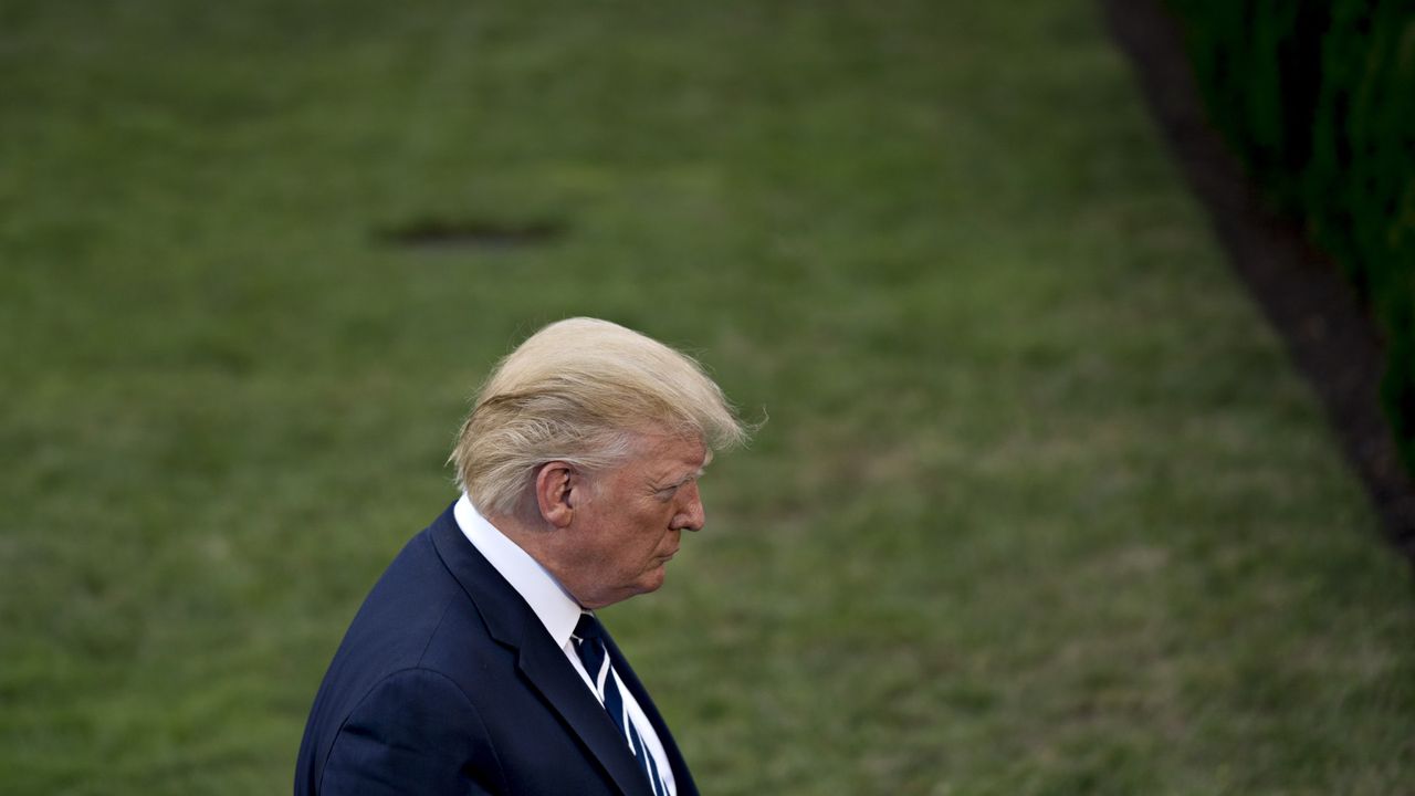  Donald Trump listens to a question while speaking to members of the media on the South Lawn of the White House in 2019