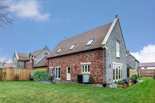 an air source heat pump outside a small self build home