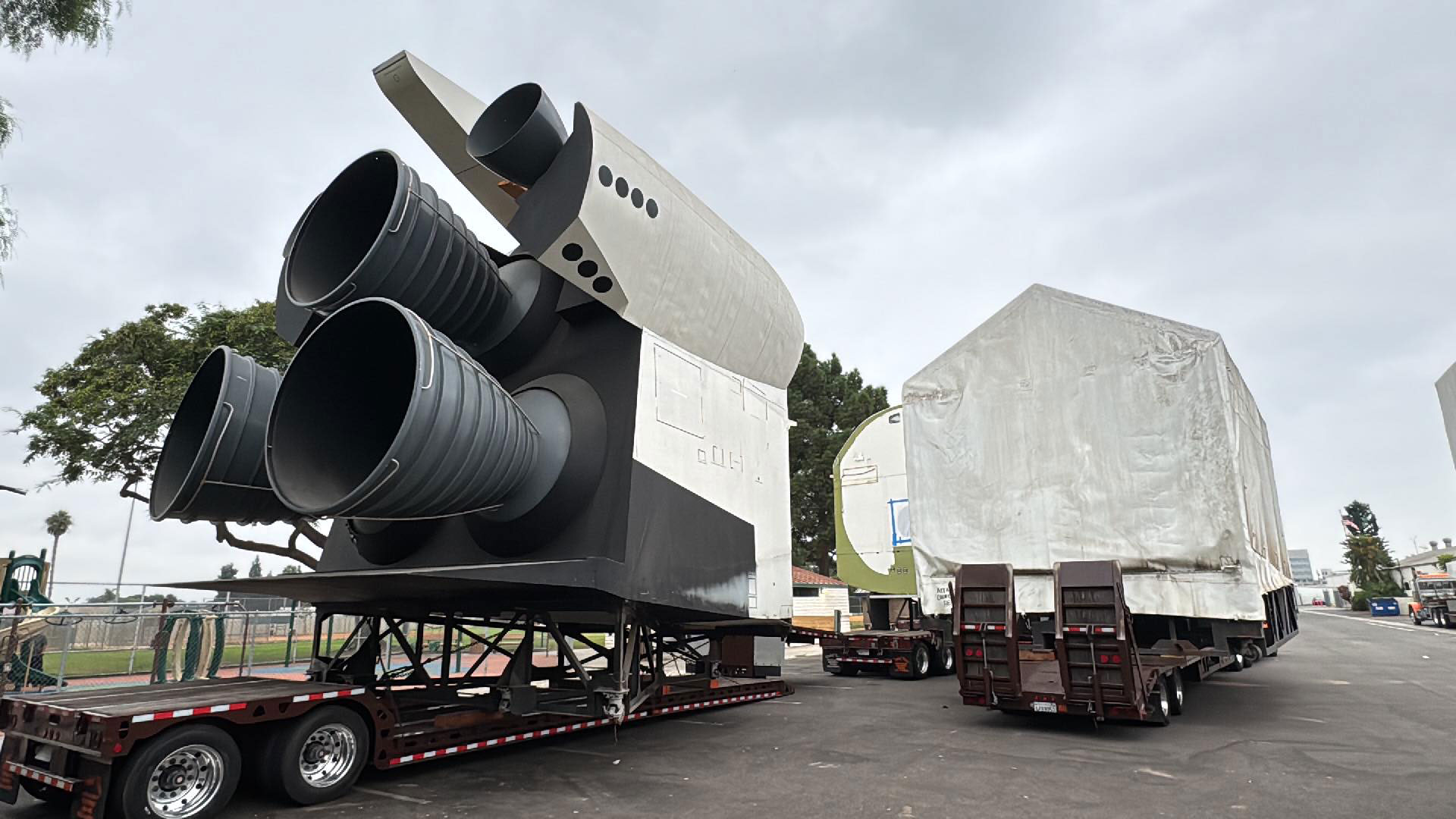 rear view of a full-size space shuttle mockup, with three black engine nozzles and a white tail section