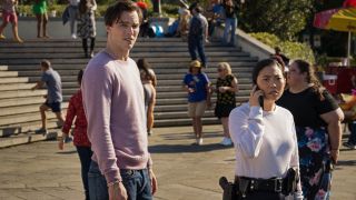 Nicholas Hoult and Awkwafina looking paranoid in a daylight crowd scene in Renfield.