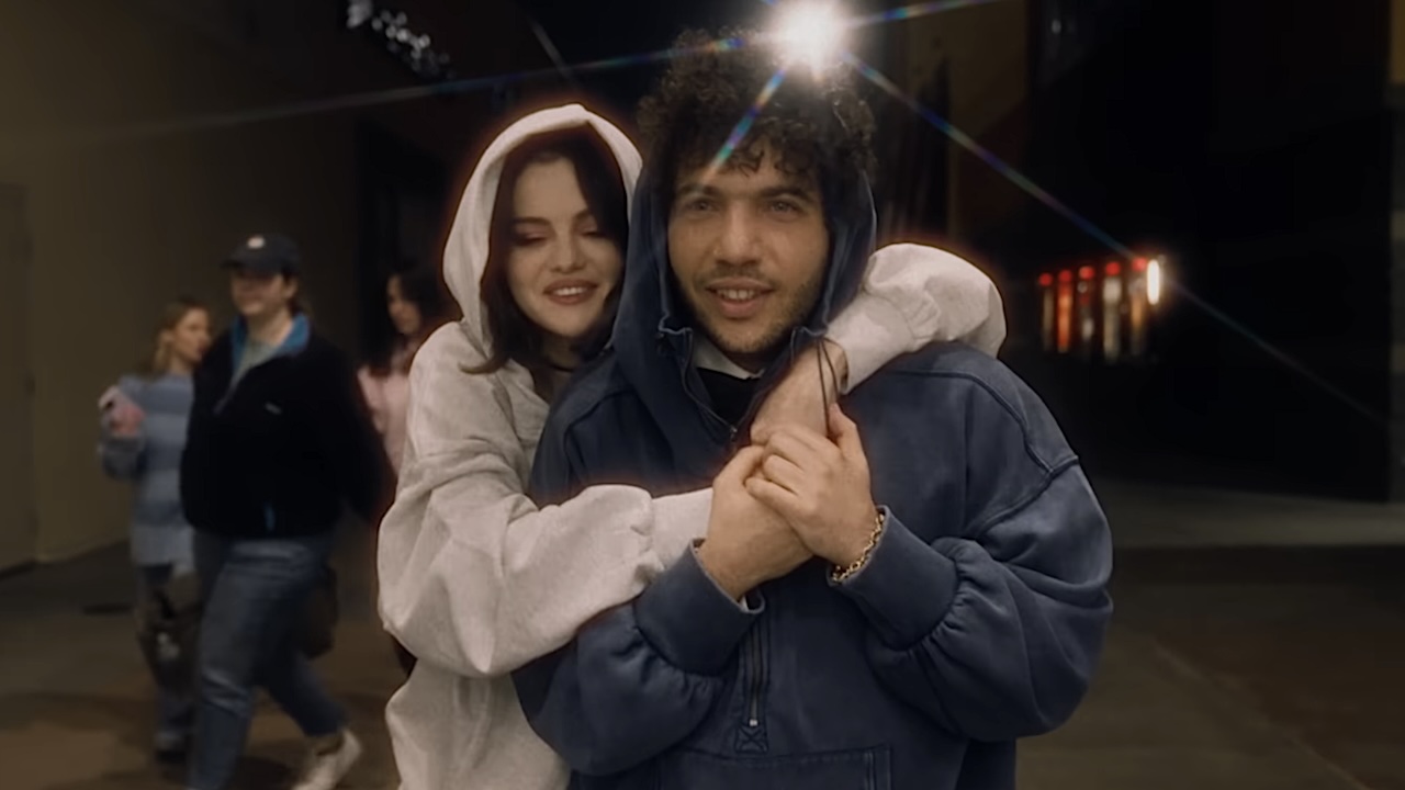 Selena Gomez and Benny Blanco hugging while wearing hooded sweatshirts in Talk music video. 