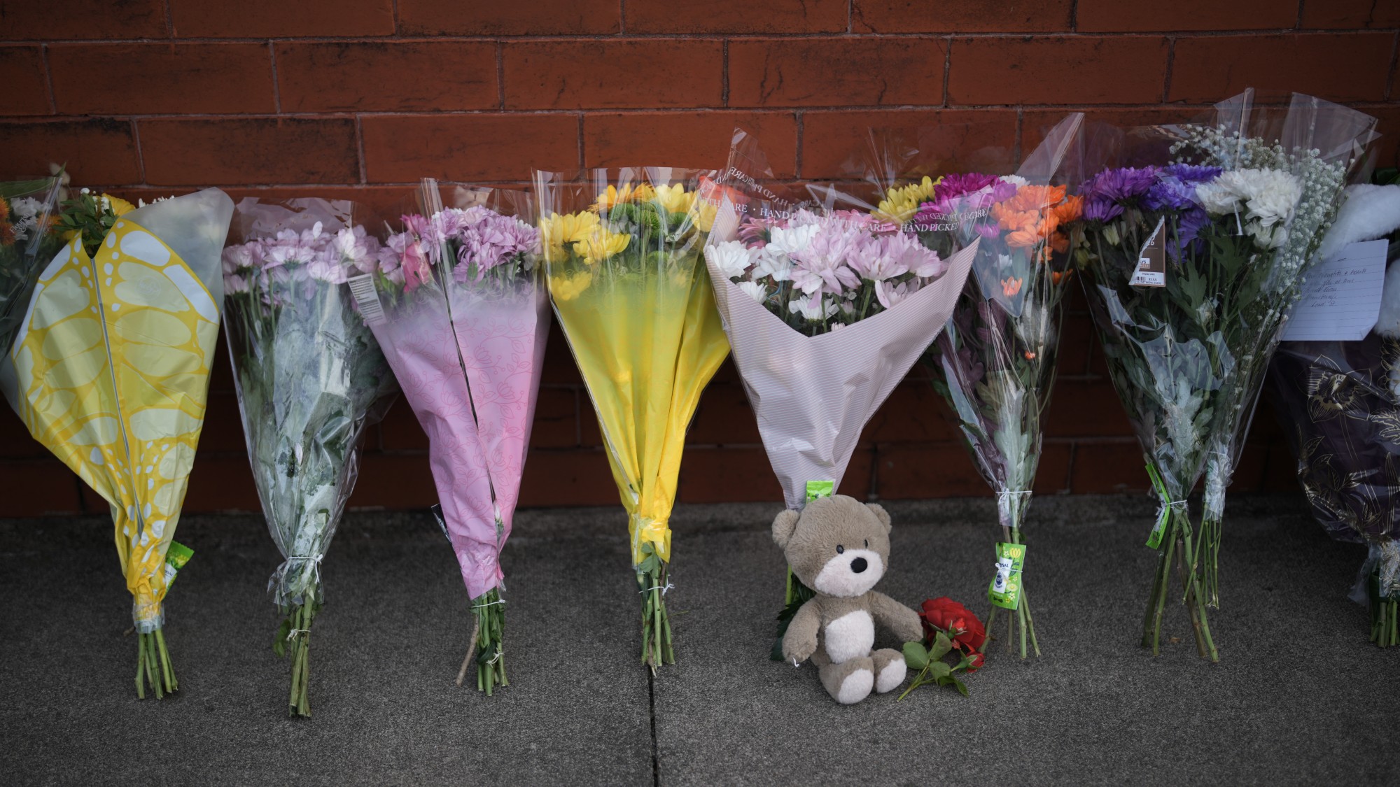 Floral tributes for victims of the 2024 Southport attacks leaning against a wall