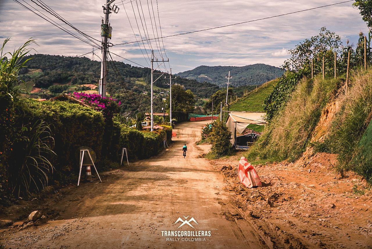 A rider passes through a village on a dirt road