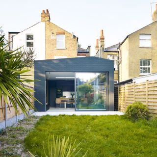 black engineering brick extension added to a London terrace, with a long garden