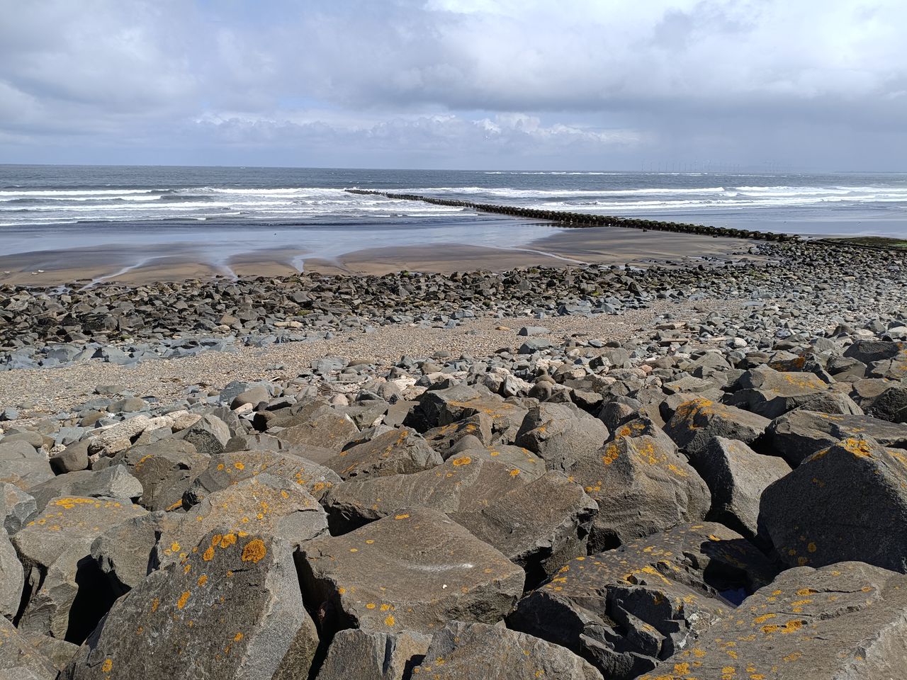 Rocky beach at low tide under a cloudy sky