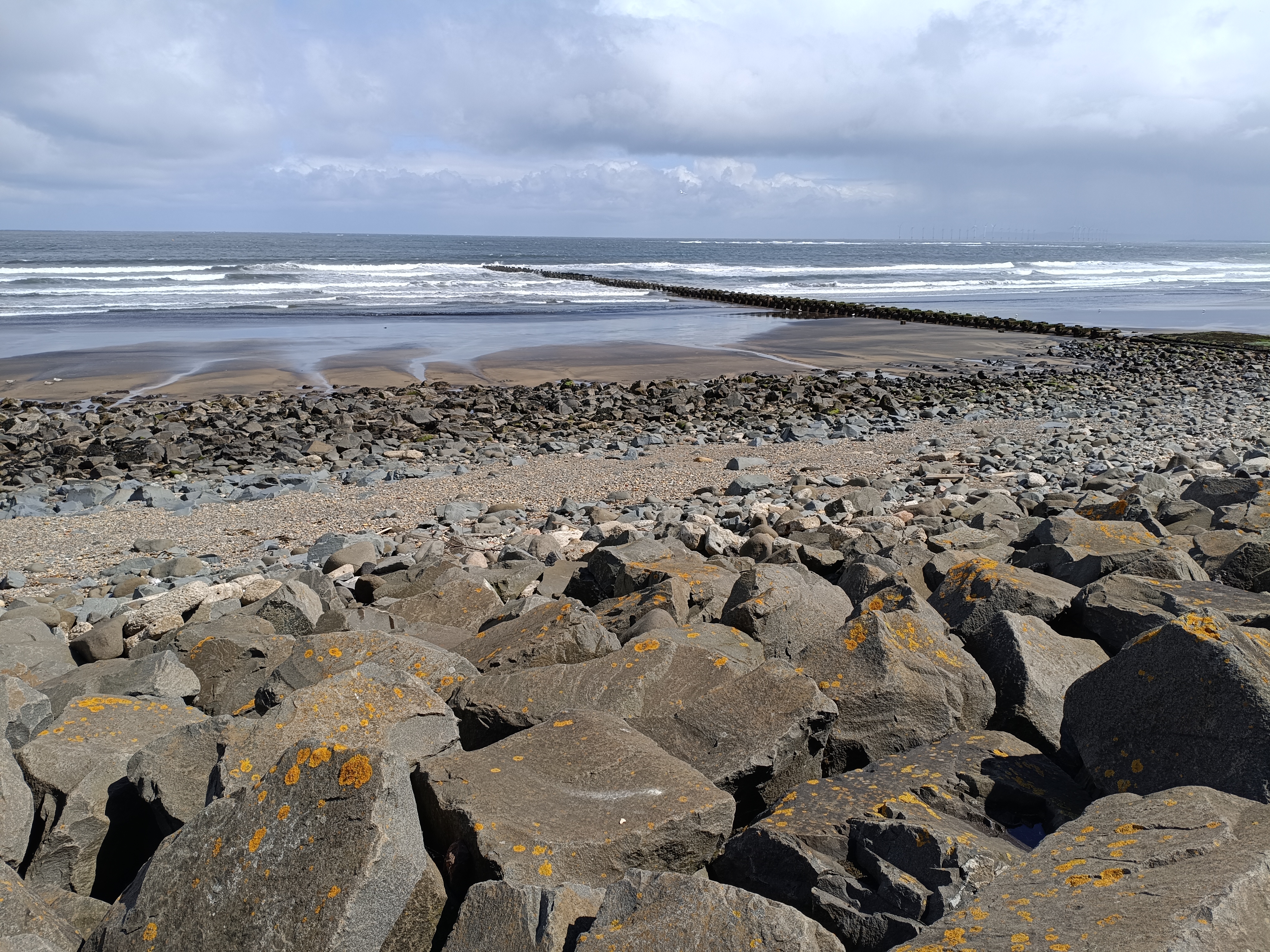 Rocky beach at low tide under a cloudy sky