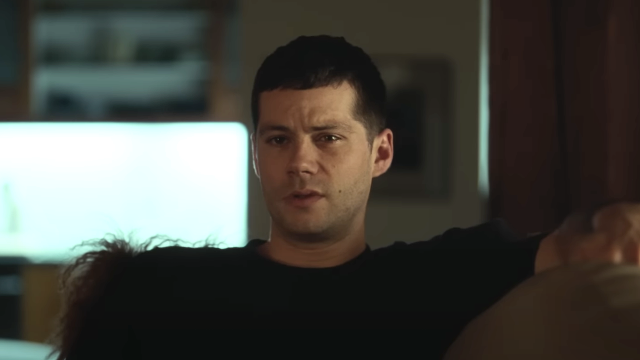 Dylan O&#039;Brien sitting on a couch in Twinless