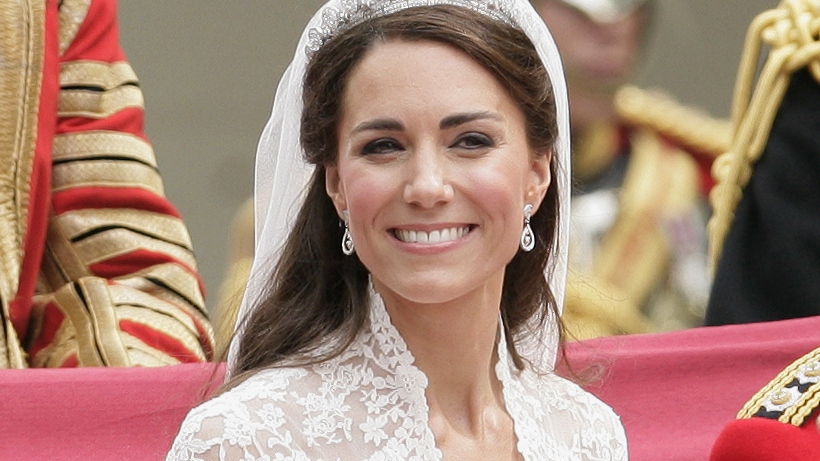 Catherine, Princess of Wales smiles as she travels down The Mall on route to Buckingham Palace in a horse drawn carriage following her wedding