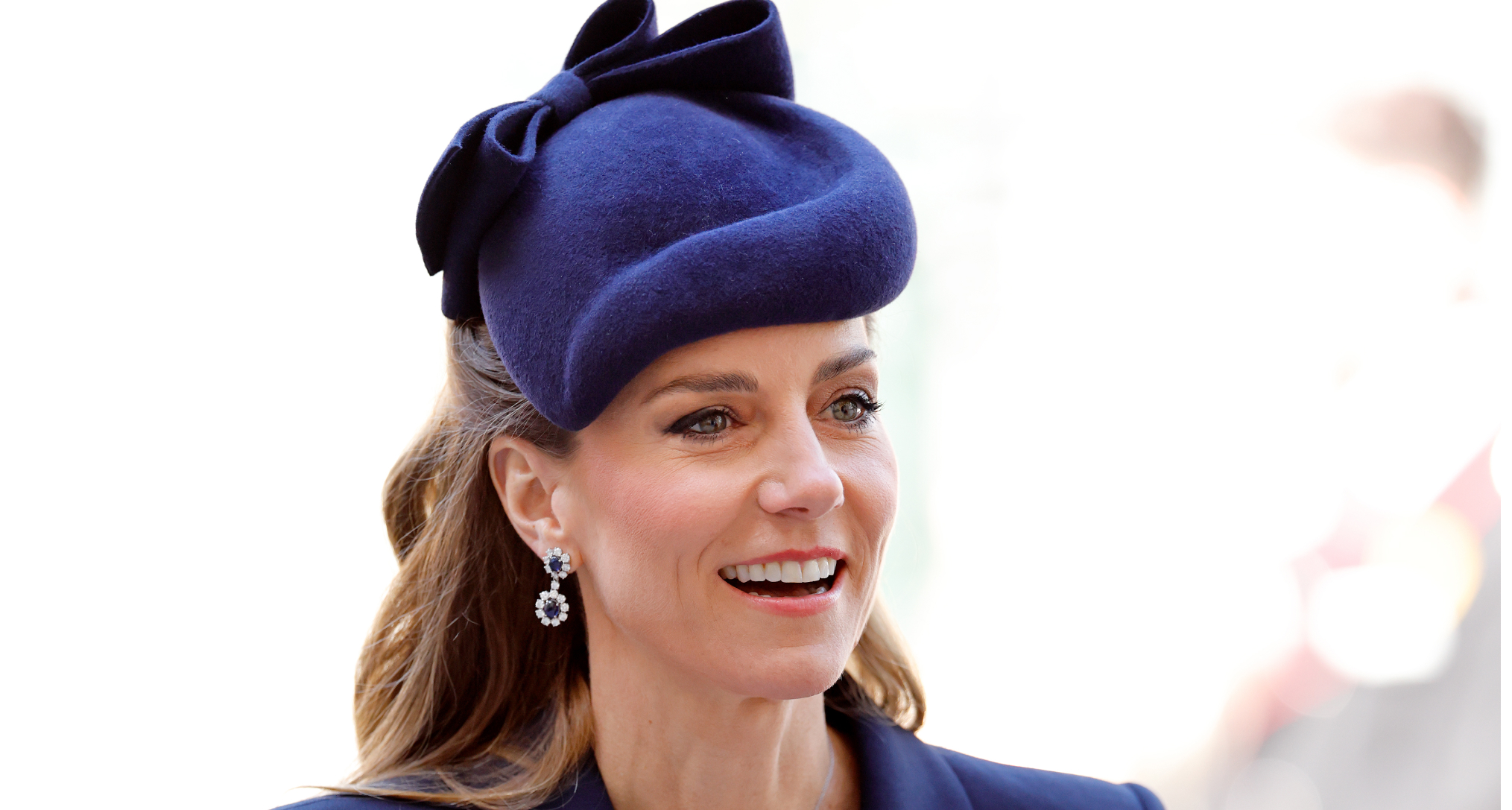 Princess Kate wearing a blue hat and smiling