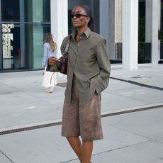 @_livmadeline wears a checked shirt, brown suede shorts, a burgundy leather shoulder bag and sunglasses